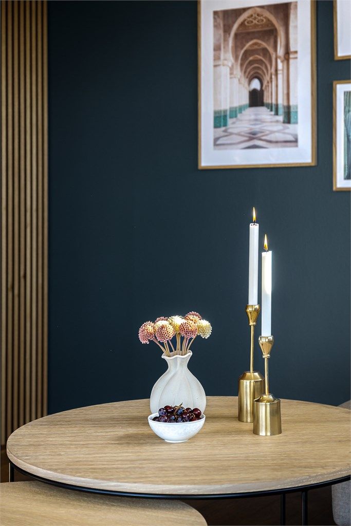 En dekorativ spilevegg i tre skaper en moderne soneinndeling i stuen.