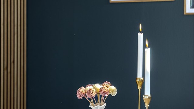 En dekorativ spilevegg i tre skaper en moderne soneinndeling i stuen.