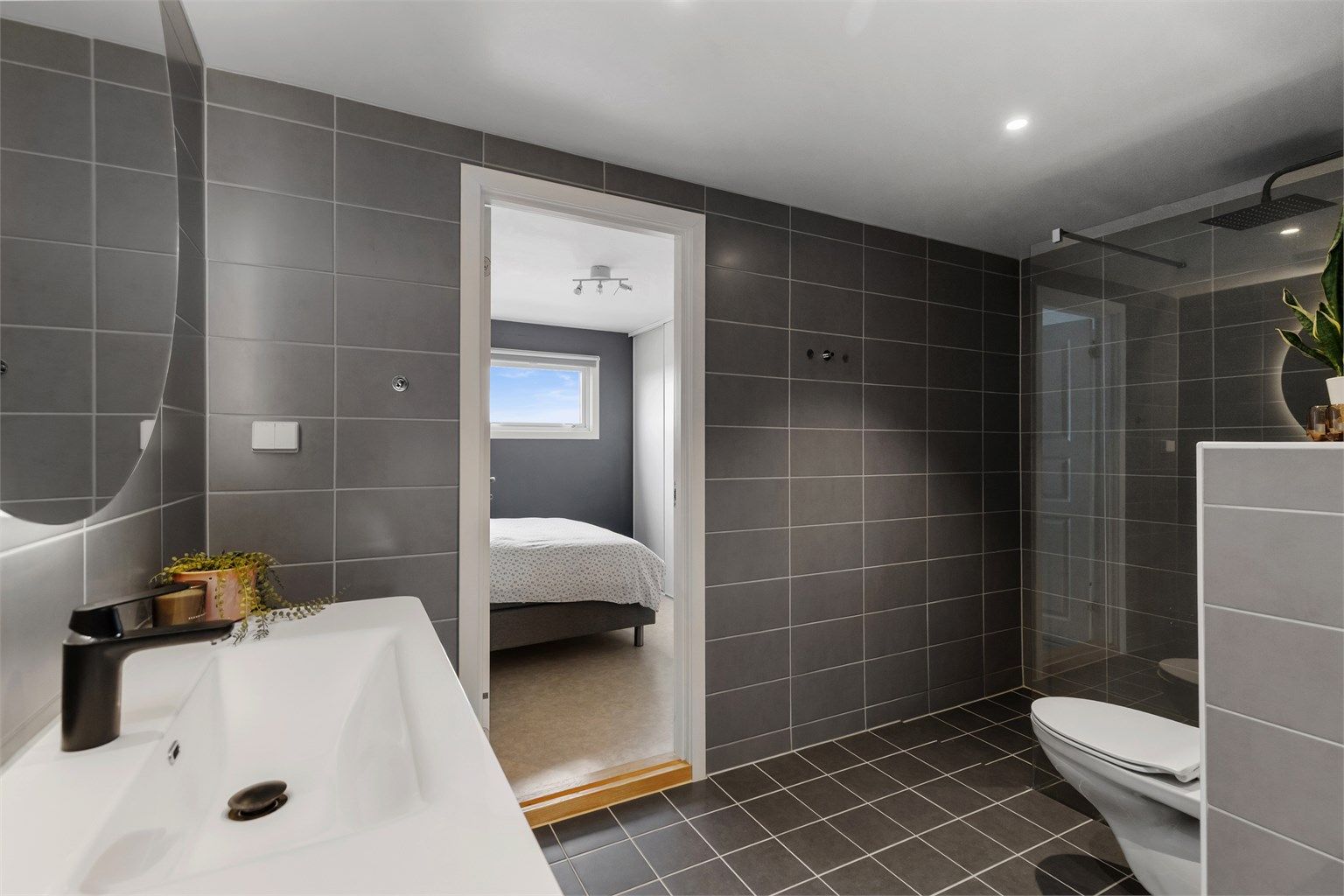 Badet har direkte adkomst fra hovedsoverommet, en praktisk en-suite løsning.