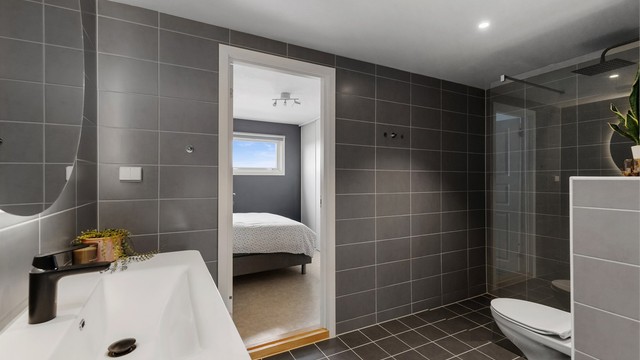 Badet har direkte adkomst fra hovedsoverommet, en praktisk en-suite løsning.