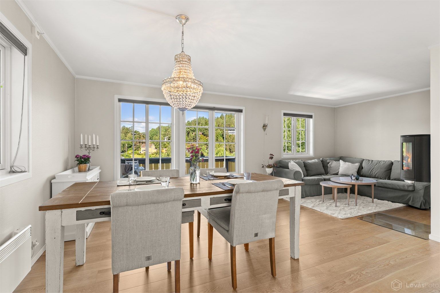 Boligen har en åpen og sosial planløsning i første etasje, med parkett på gulv og en peisovn i stuen.
Foto: Løvås Foto