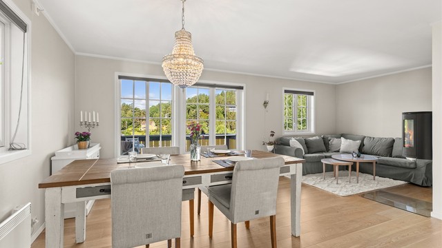 Boligen har en åpen og sosial planløsning i første etasje, med parkett på gulv og en peisovn i stuen.
Foto: Løvås Foto