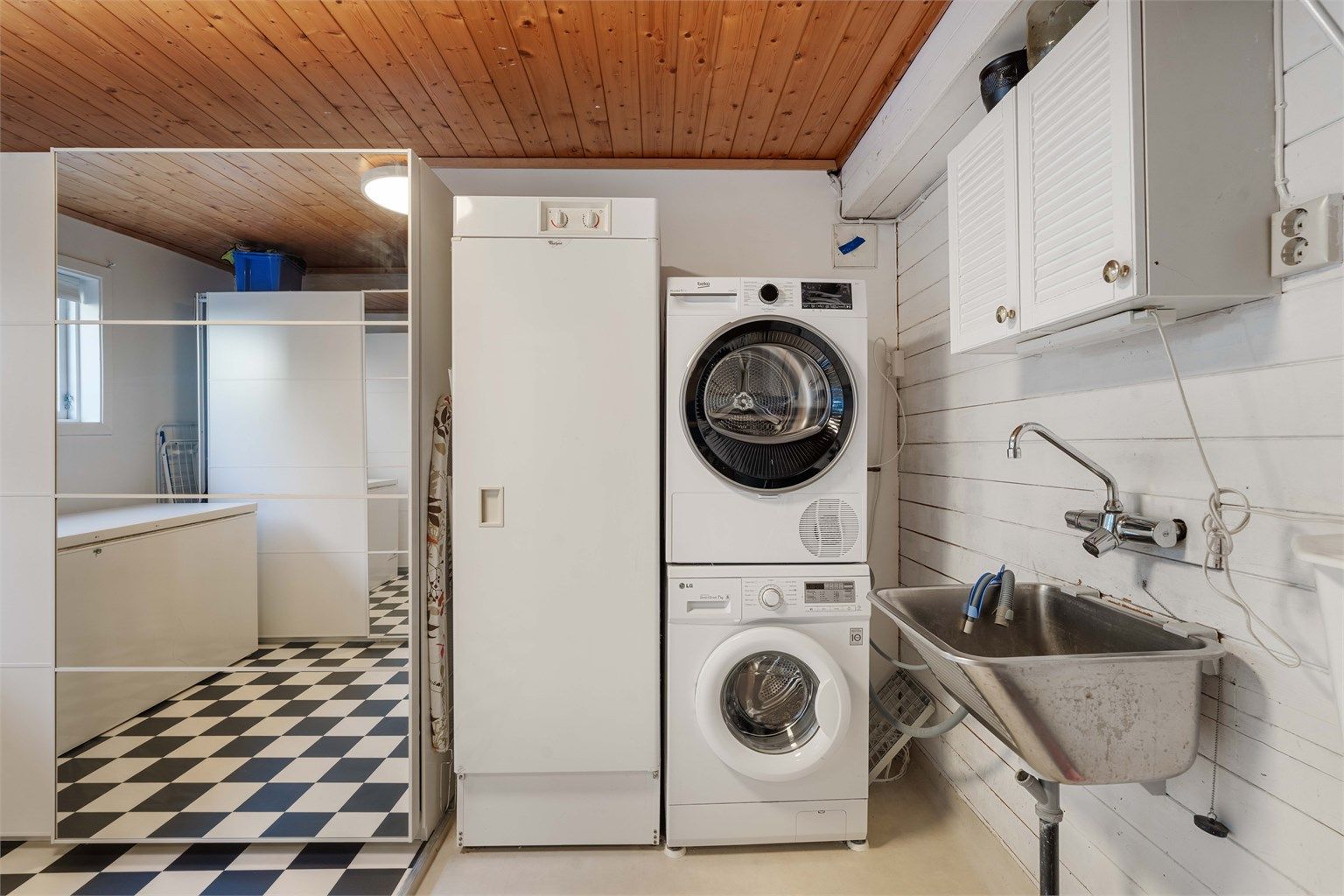 Praktisk vaskerom med utslagsvask og opplegg for vaskemaskin og tørketrommel.