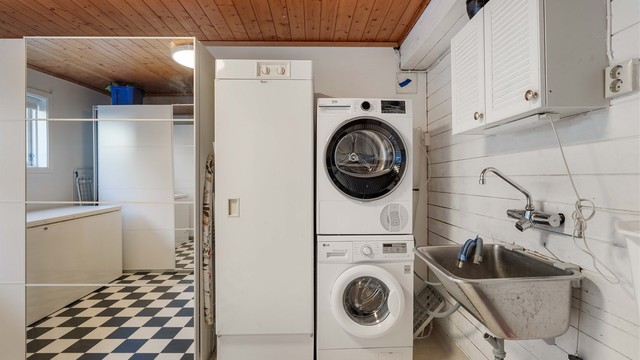 Praktisk vaskerom med utslagsvask og opplegg for vaskemaskin og tørketrommel.
