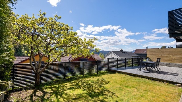Hagen er pent opparbeidet med plen og beplantning.