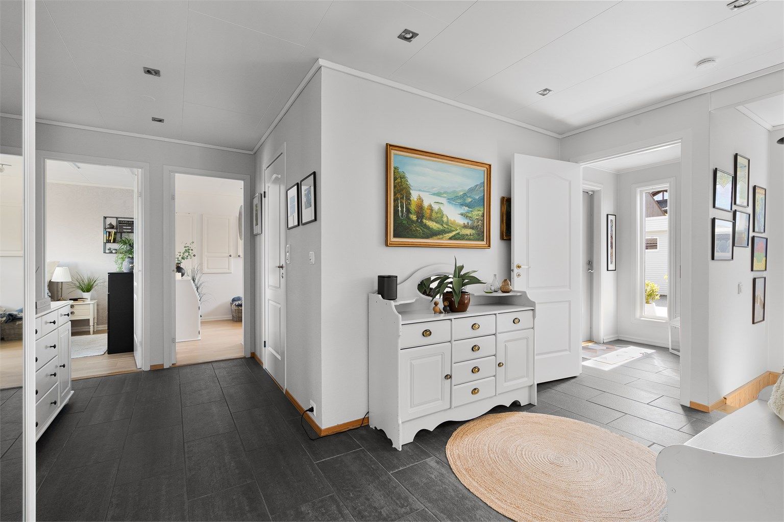  Videre inn til hall hvor det er fliser på gulv og skyvedørsgarderobe til oppbevaring. 
