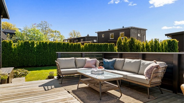En skjermet og privat uteplass med god plass til både sofagruppe og spisebord.
