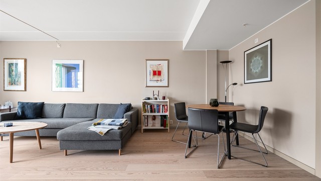 Gjennomgående materialvalg med parkettgulv og malte flater skaper en helhetlig og rolig atmosfære.