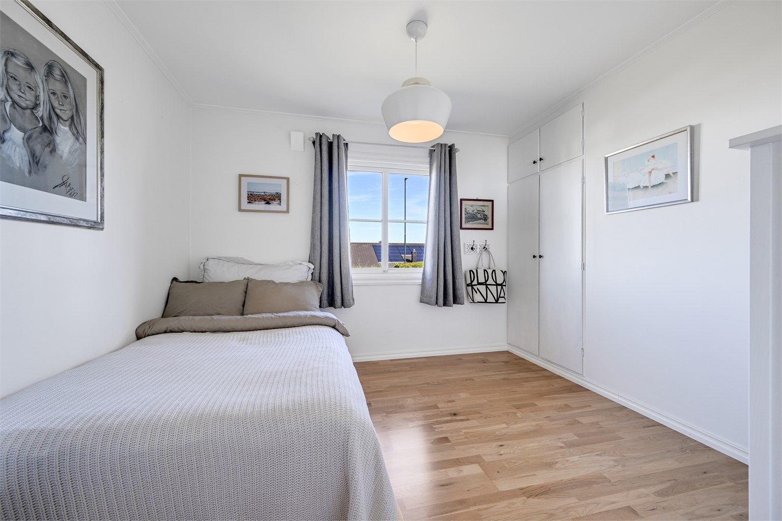 Lyst og trivelig soverom med plass til seng og garderobe.