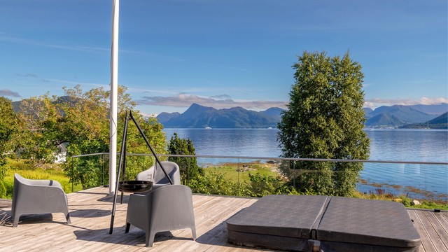 Nedfelt jacuzzi på markterrassen med utsikt over fjorden.