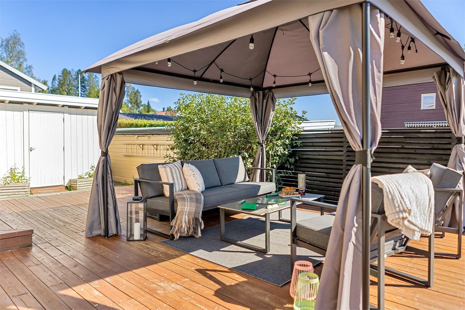 En overbygd loungesone gjør terrassen like innbydende på varme sommerdager som sene sommerkvelder.
