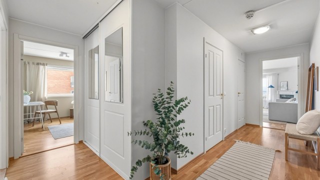 Romslig entré med skyvedørsgarderobe.