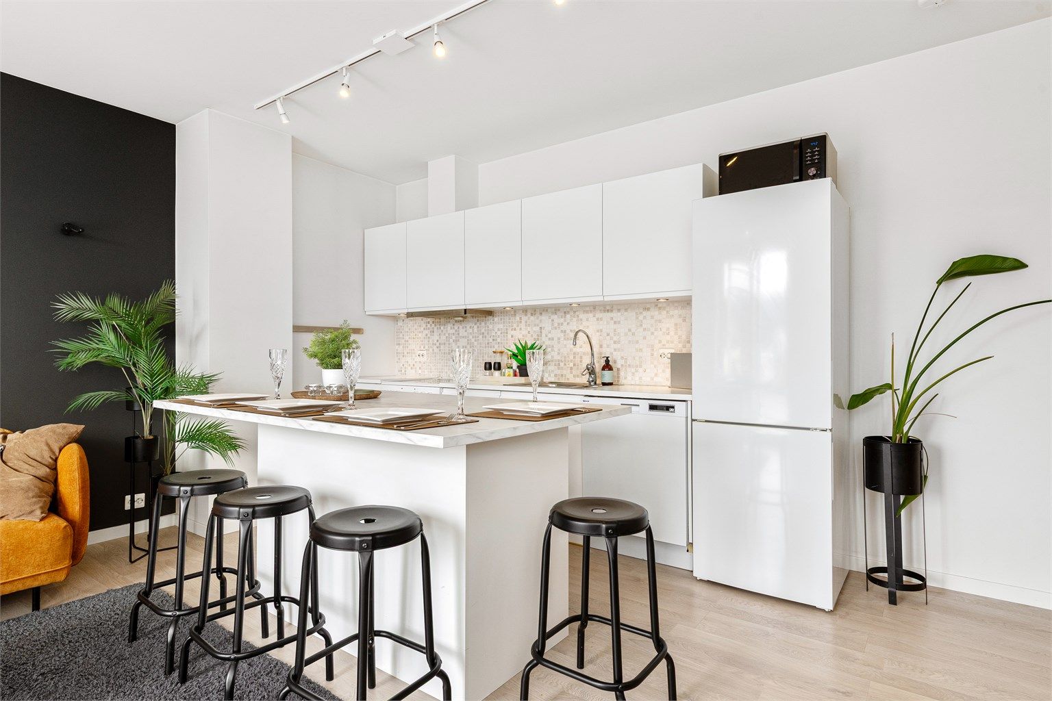 Kjøkkeninnredningen med hvite glatte fronter fra 2016. Flott praktisk kjøkkenøy mot stuedel med sitteplasser. Noe nyere benkeplate på kjøkkenøya