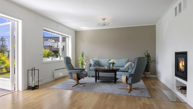 Lys stue med integrert peisovn for ekstra varme. Utgang til terrasse og hage.