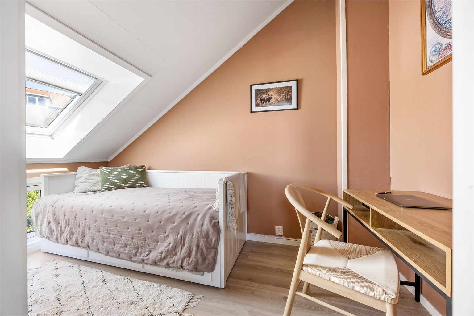 Rommet er lyst og har plass til seng og en liten arbeidsplass.