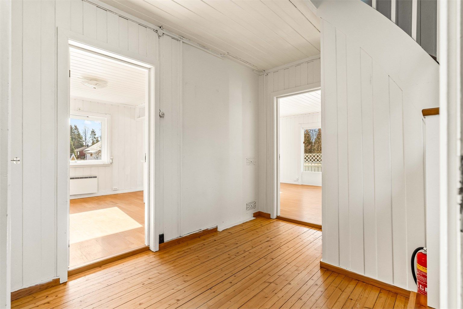 Gangen har heltre gulv og forbinder etasjens rom. Trappen i trekonstruksjon leder opp til andre etasje.