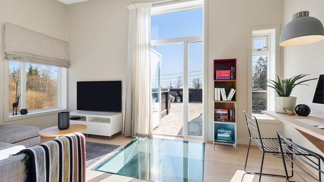 Opp trappen i 2.etasje kommer du først til stuen. Her er det plass til sittegruppe, TV-område og skrivebord/kontorløsning. Stilig detalj med glassgulv ned mot entreen i 1.etasje. Fra stuen er det utgang til en stor takterrasse.