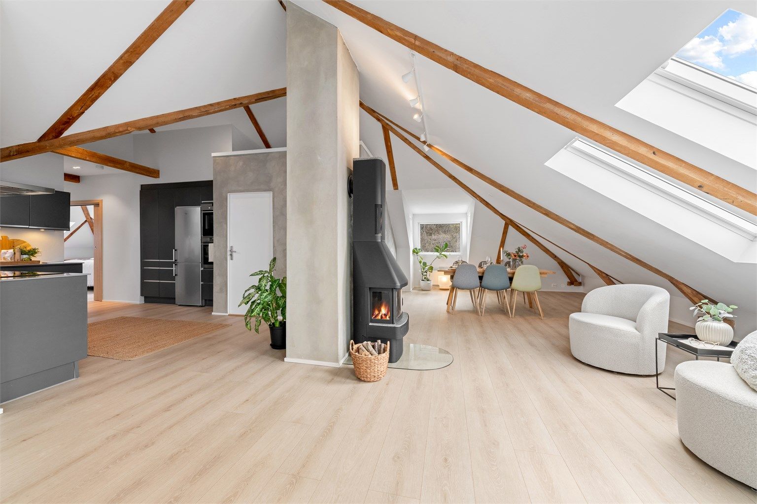 Den sentralt plasserte peisovnen gir både varme og en hyggelig atmosfære i det store allrommet.