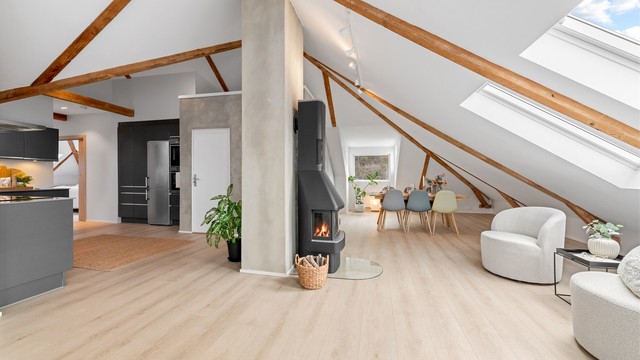 Den sentralt plasserte peisovnen gir både varme og en hyggelig atmosfære i det store allrommet.