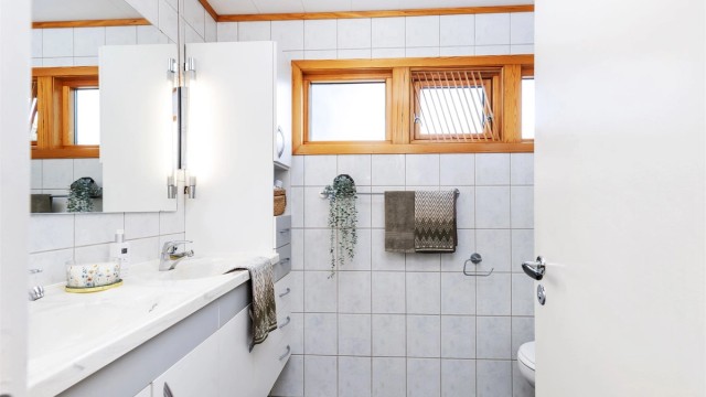 Badet i 1. etasje ble oppgradert i 2001 og er innredet med flislagte gulv og vegger, gulvvarme, dusjhjørne, vegghengt toalett og servantinnredning.