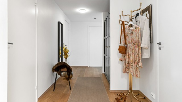 Gjennomgående parkett og malte flater gir et helhetlig og stilrent uttrykk gjennom hele leiligheten.