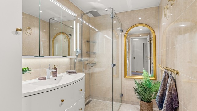 Badet er fra ca. 2015 og har flislagt gulv med varme, downlights i taket og dusjsone med regndusj.