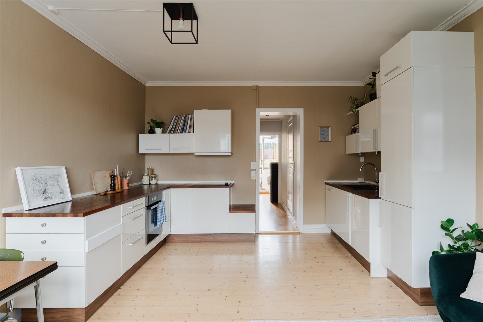 Kjøkkenet fra 2010 har hvite, slette fronter og en benkeplate av mørkt tre og har godt med benk- og skapplass.