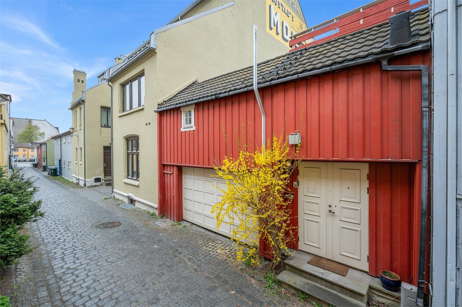 Bygårdens inngang fra Tyrkrisveita samt port for innkjøring i egen romslig carport. Attraktiv beliggenhet i Midtbyen med gangavstand til Trondheim Torg, Byhaven, restauranter, kaféer og kollektivtransport. 