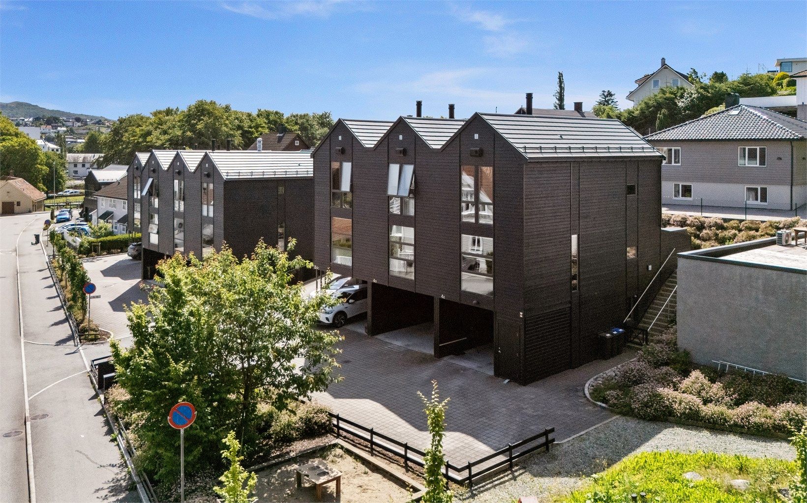 Det er carport integrert i boligen, noe som gir enkel og tørrskodd adkomst fra bil til huset.  Det er også laget utvendig der, med 2 dører og som har fungert perfekt til oppbevaring av motorsykkel.  Dermed praktisk løsning også for de med barnevogn osv.