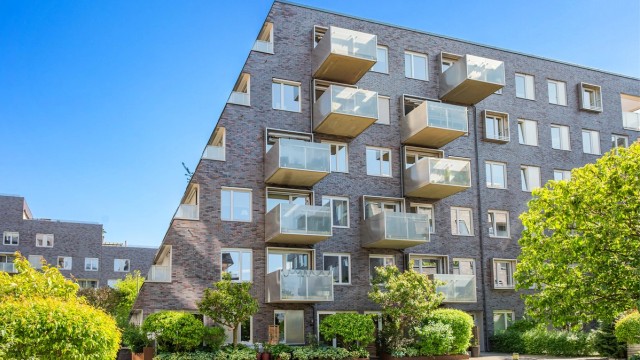 Fasade, leiligheten til venstre. Unik rekkehusfølelse ved direkte adgang til plen og sittegrupper i atriumet. Legg merke til at leiligheten oppleves usjenert.