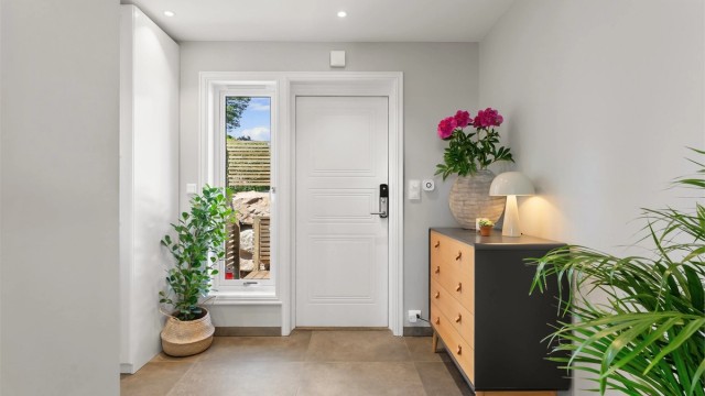 Entré i første etasje med fliser på gulv, gulvvarme og downlights i himling.