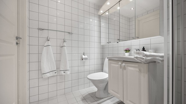 Vegghengt servantinnredning med speilskap og elektrisk gulvvarme på badet.