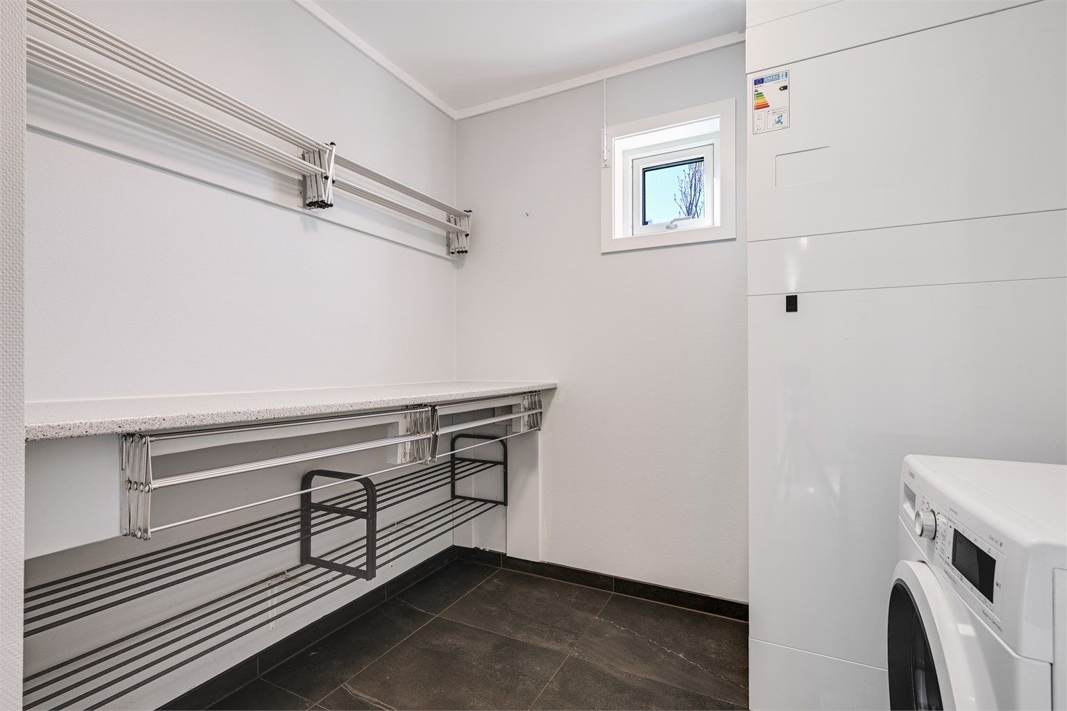 Praktisk, separat vaskerom med flislagt gulv, elektriske varmekabler og opplegg for vaskemaskin.