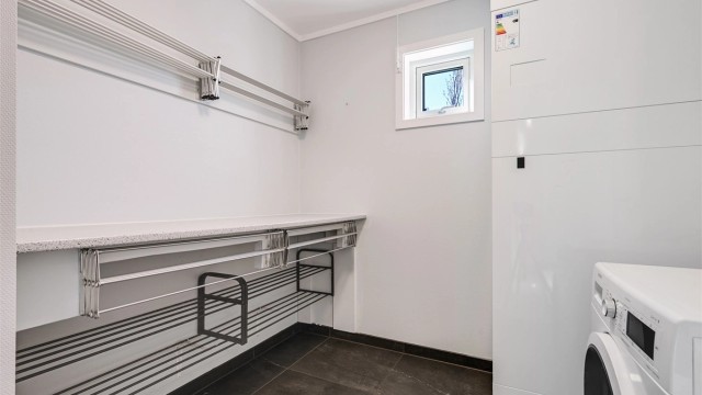 Praktisk, separat vaskerom med flislagt gulv, elektriske varmekabler og opplegg for vaskemaskin.