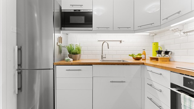 Kjøkkenet har flislagt gulv og delikate fliser mellom benkeplate og overskap.