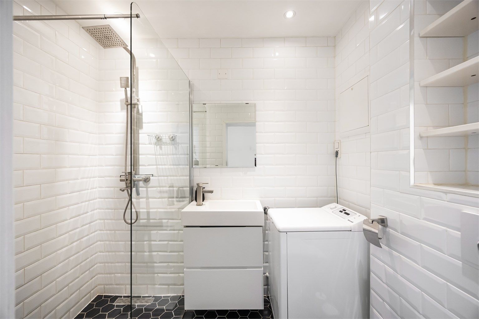 Badet er innredet med vegghengt servant og speil over servant.