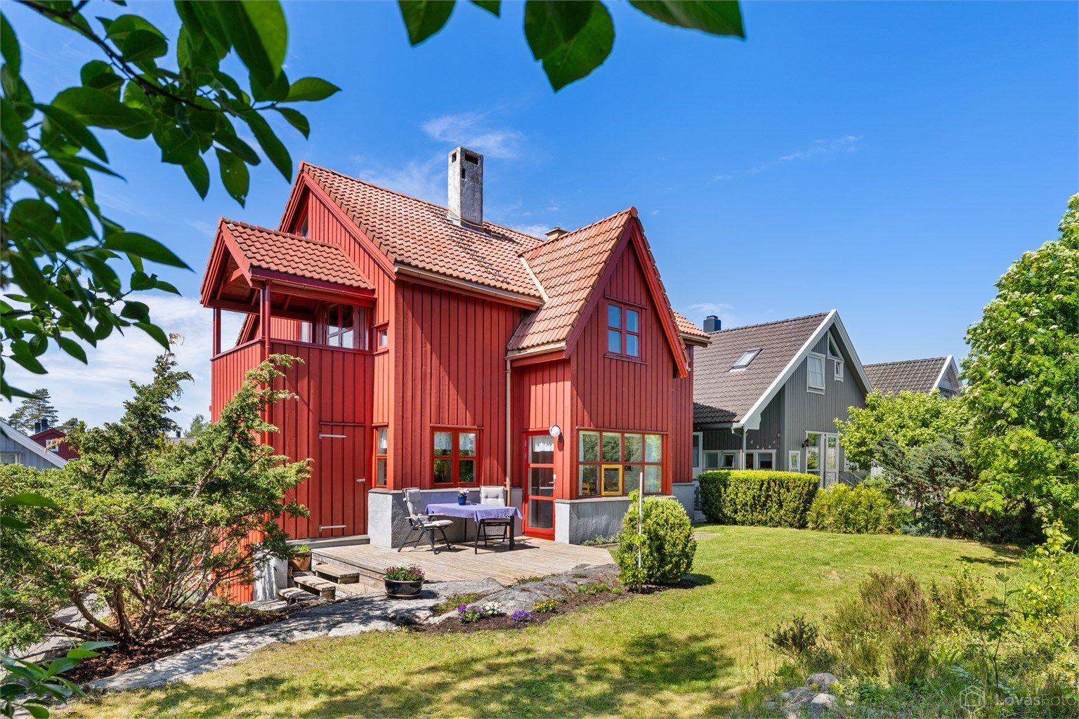 Fasaden er kledd med stående trekledning, og taket har takstein.