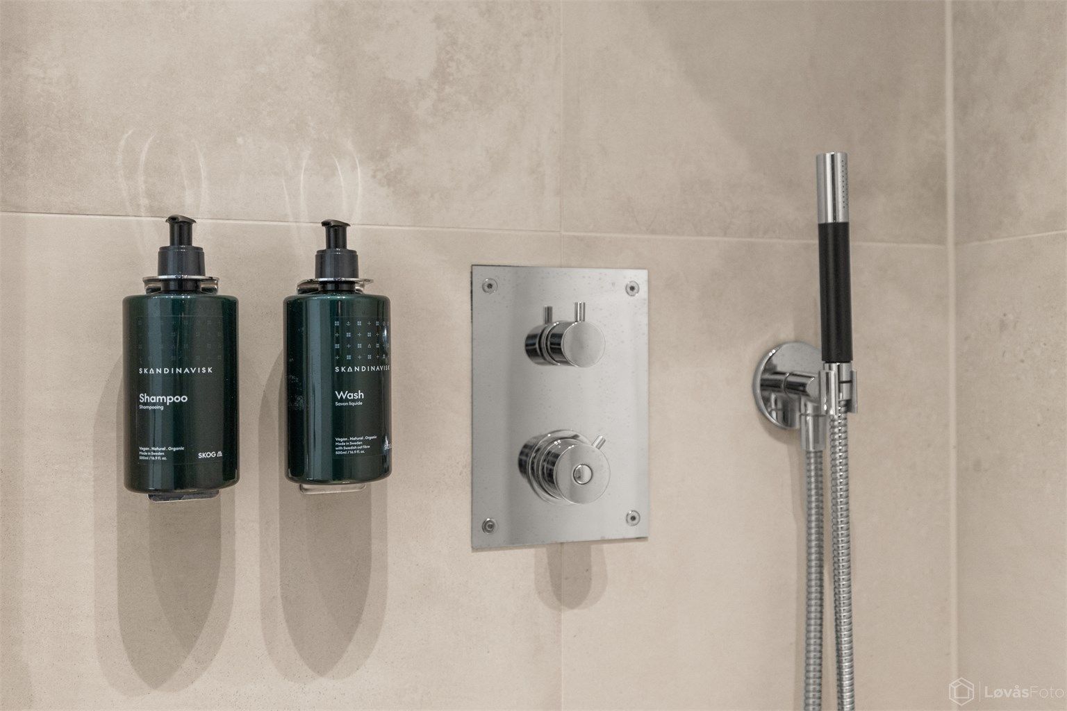 usjnisje med glassvegg og integrert dusjarmatur i vegg og med integrerte rør i vegg til hånddusj og regnfallsdusj