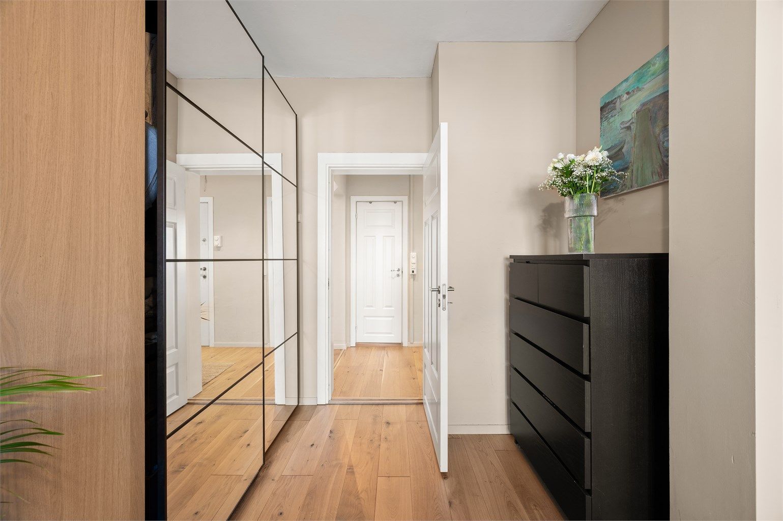 Speilgarderoben i gangen bidrar til en økt romfølelse og reflekterer lyset.