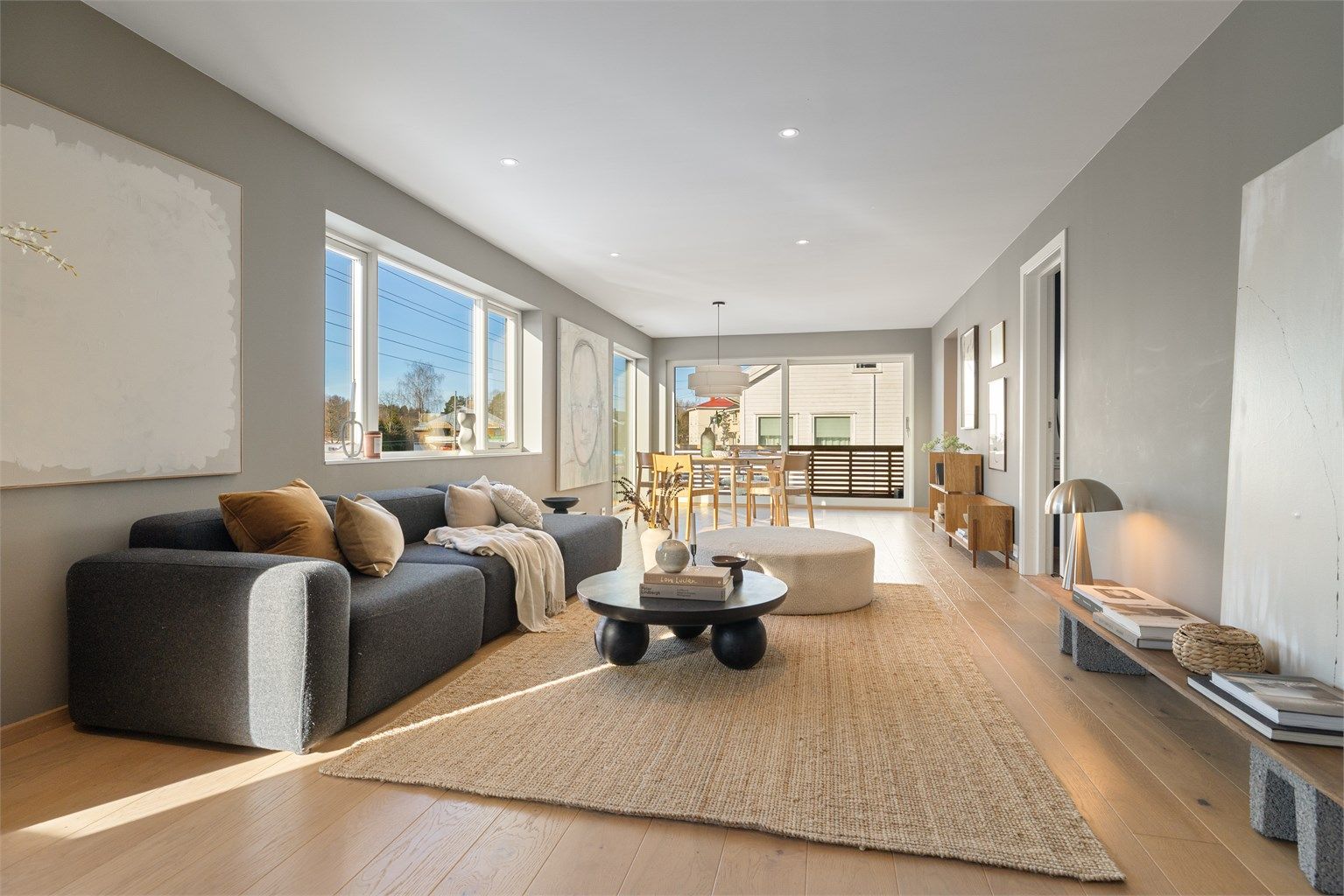 Lys og romslig stue med god plass til stor sofagruppe og spisebord i tilknytning til kjøkkenet