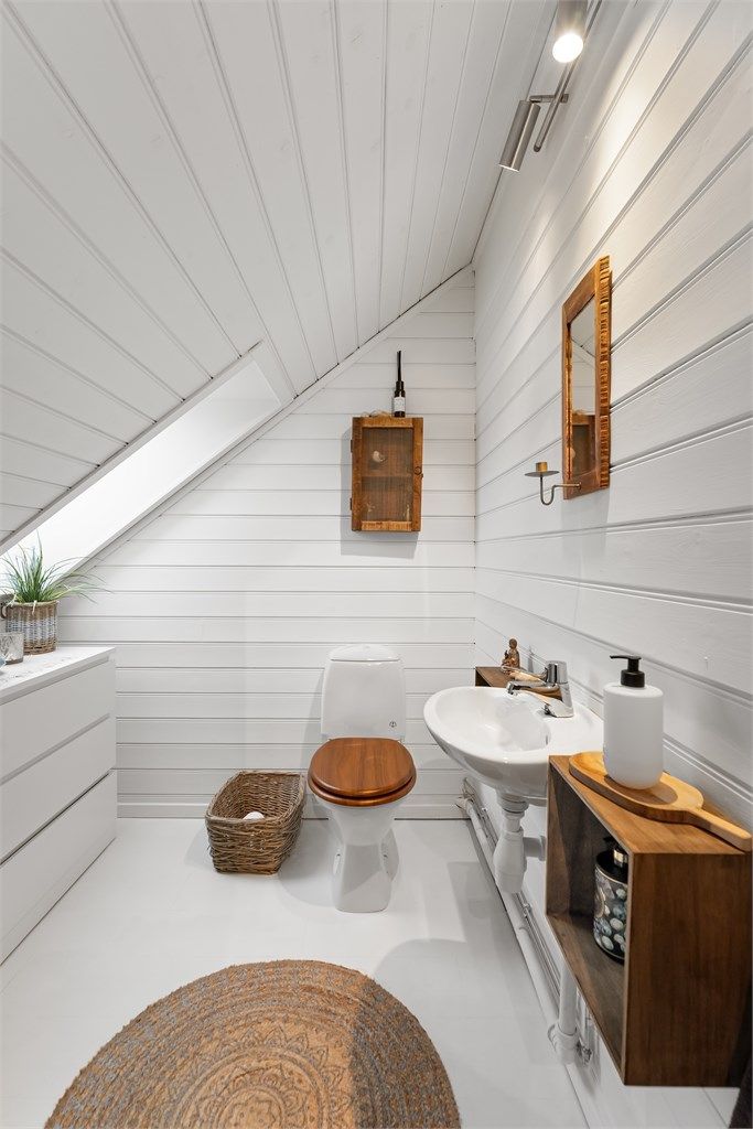 Toalettrom innredet med toalett og vegghengt servant, fungerer som et praktisk tillegg til etasjen