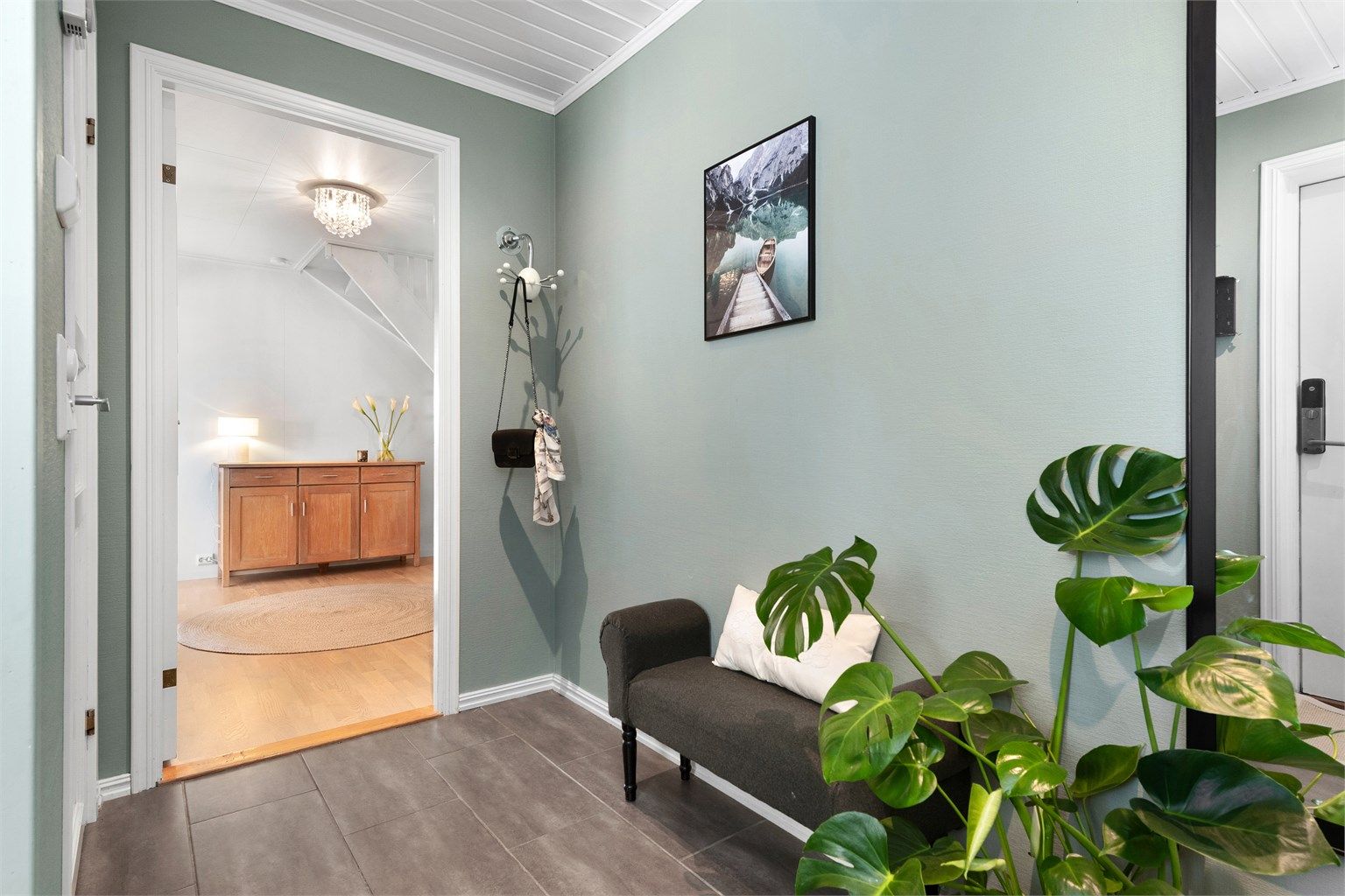 Vindfanget har flislagt gulv med gulvvarme og leder videre inn til en romslig hall/trapperom