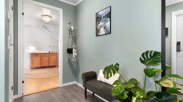 Vindfanget har flislagt gulv med gulvvarme og leder videre inn til en romslig hall/trapperom