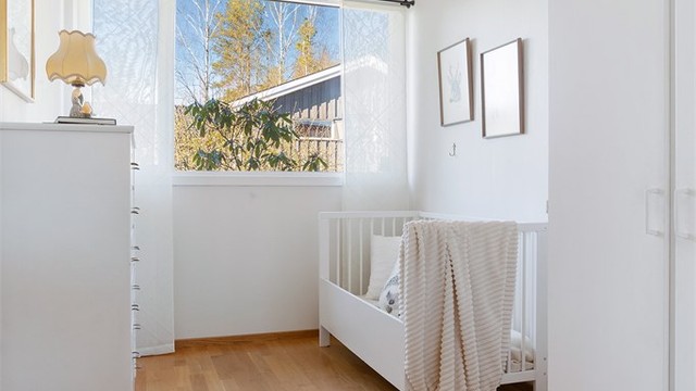 Et lyst soverom med innebygde garderobeskap.