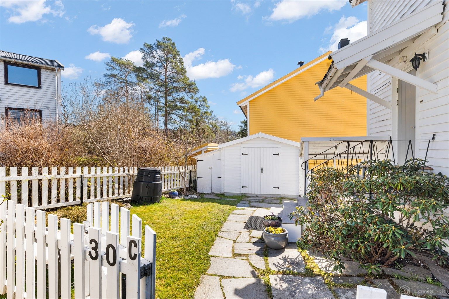 Gangsti med steinheller leder frem til inngangsdøren.