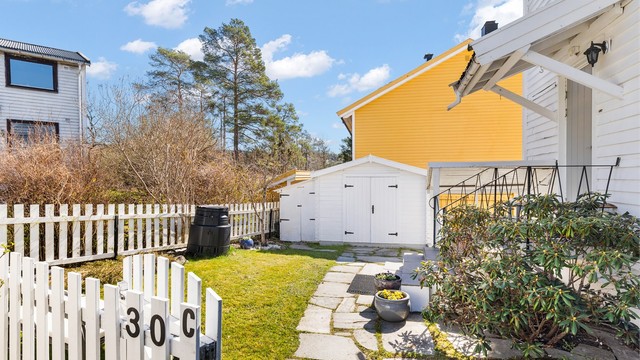 Gangsti med steinheller leder frem til inngangsdøren.