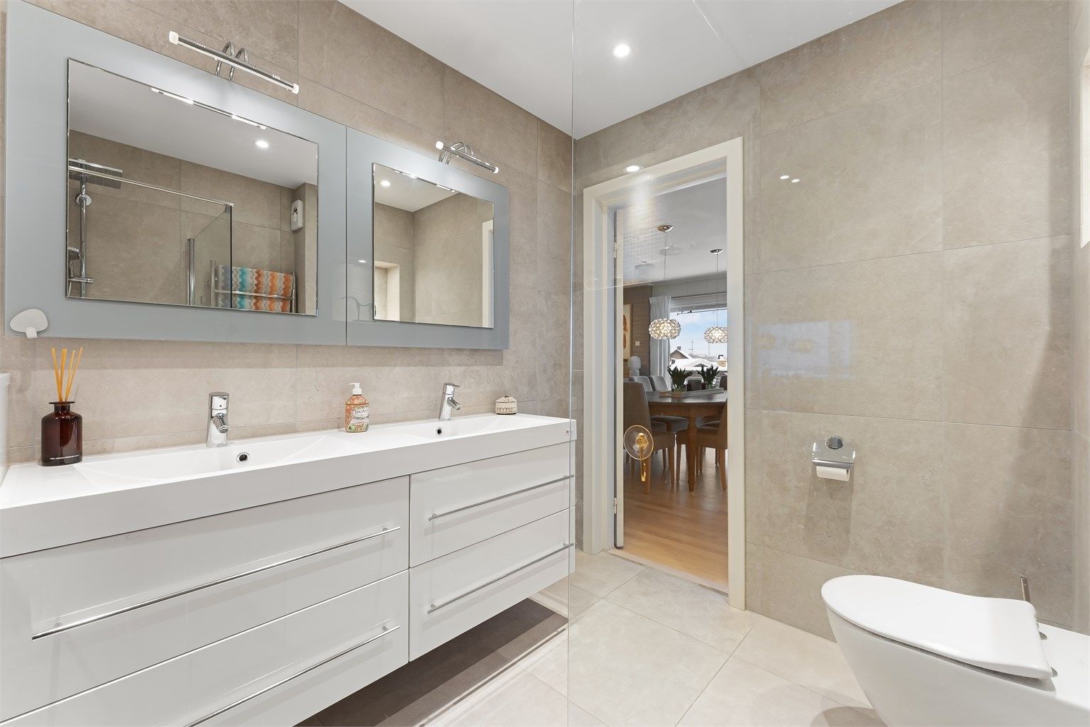 Badet er utstyrt med vegghengt toalett og nedstøpte varmekabler i gulvet for komfort.