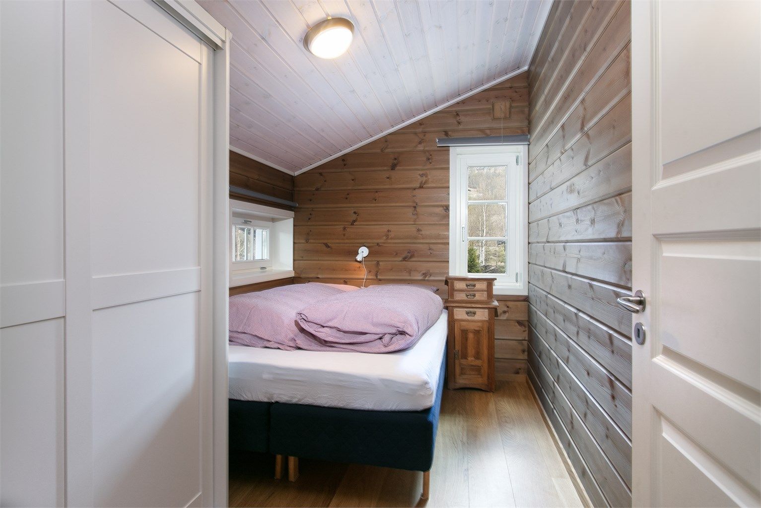 Det ene av to soverom i andre etasje, utstyrt med skyvedørsgarderobe.