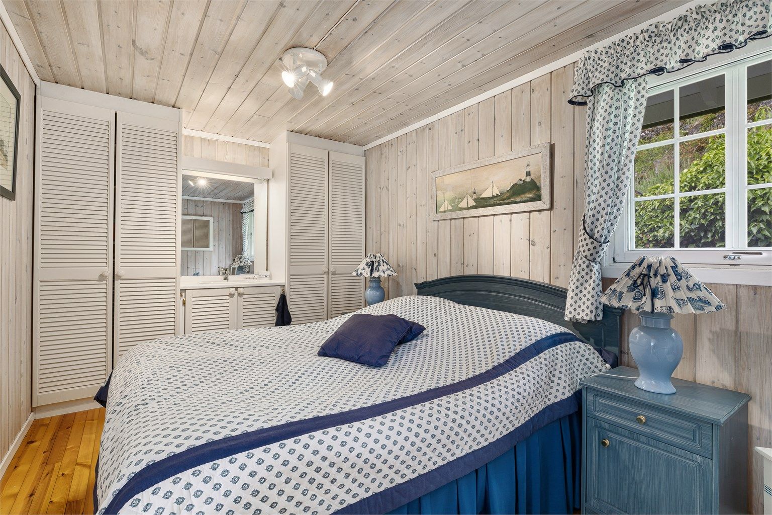 Lyst hovedsoverom med servant og garderobeskap.