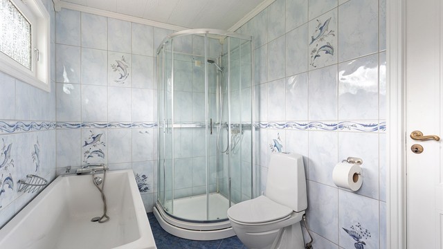 Badet er utstyrt med både dusjkabinett og badekar samt gulvstående toalett.